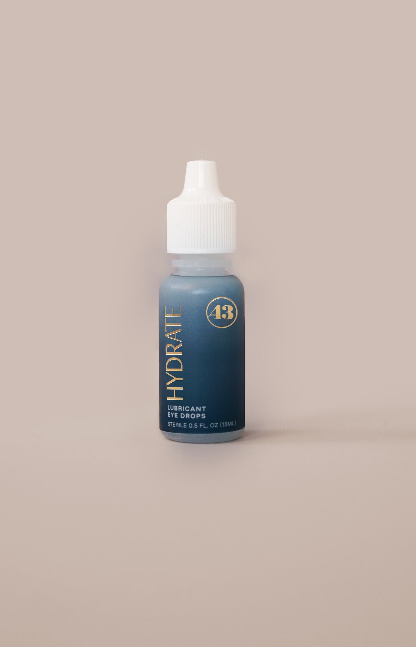 eye drop product bottle with teal label and gold text reading "hydrate lubricant eye drops"