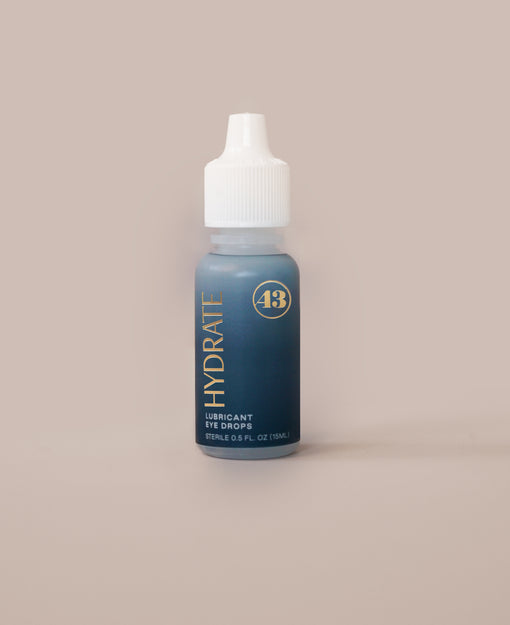 eye drop product bottle with teal label and gold text reading "hydrate lubricant eye drops"