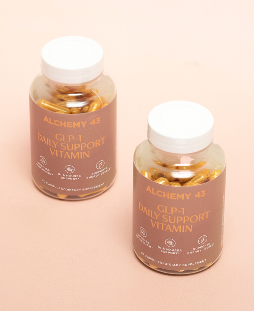 two GLP-1 vitamin bottles next to each other on a pinky-beige background. the bottles have tan labels and gold text reading "Alchemy 43 GLP-1 Daily Support Vitamin"