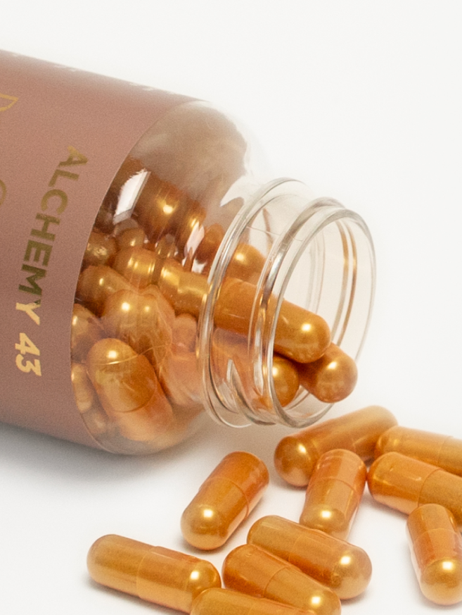 close up of GLP-1 vitamin bottle on its side with gold pill capsules spilling out