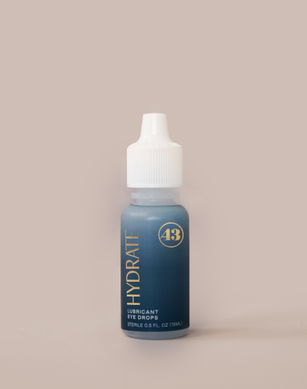 eye drop product bottle with teal label and gold text reading "hydrate lubricant eye drops"